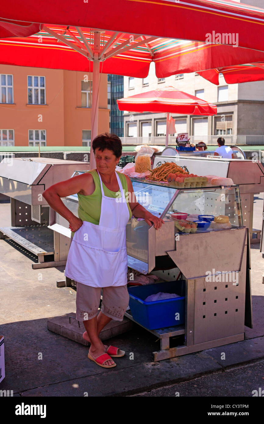 Eine Frau-Verkäufer mit ihrem Fleischprodukten unter einem roten Regenschirm am Sonntagsmarkt in Dolac-Platz Zagreb Stockfoto