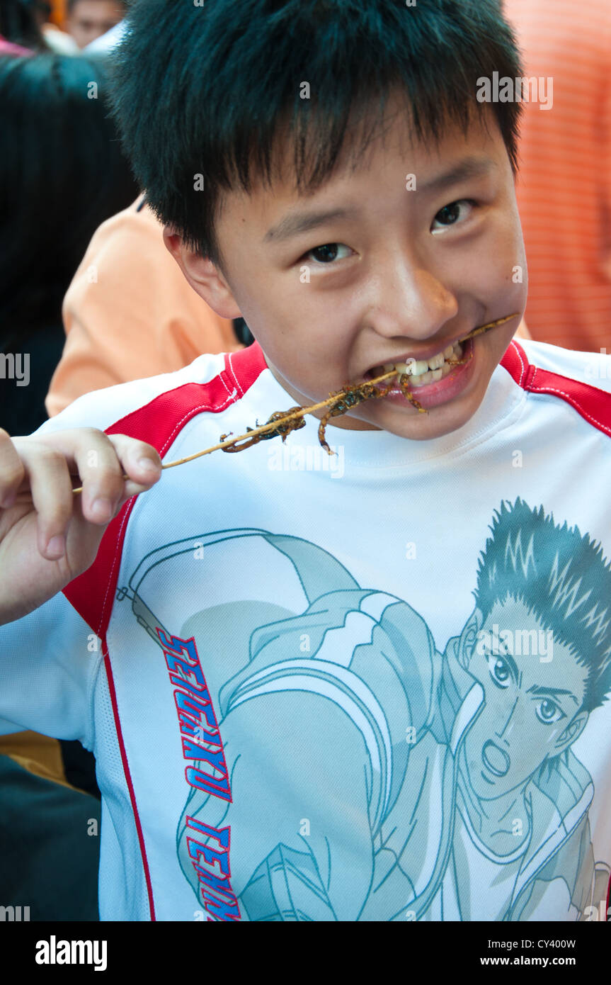 Chinesischen jungen Essen Skorpione. Stockfoto