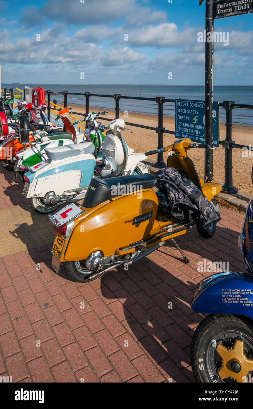Eine Reihe von Mods Vespa Roller Mopeds promenade Vespas auf Cleethorpes direkt am Meer mit Strand im Hintergrund Stockfoto