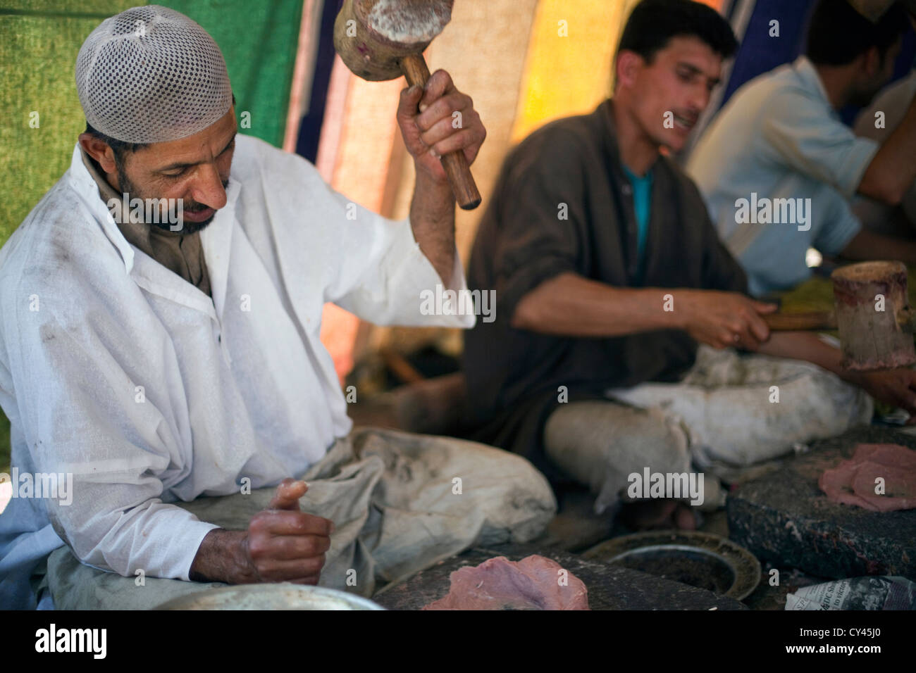 Wazas oder Köche in der Wazwan Tradition Pfund Lamm wie bereitet sie eine Gericht namens Ghustaba (Lamm Kugeln) in einem Wazwan fest. Stockfoto