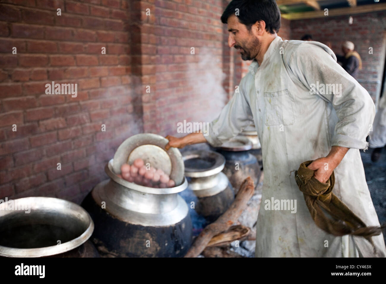 Eine Waza oder Kochen in der kaschmirischen Tradition Tipps Lamm Kugeln in einen Topf geben, wie er Nahrung für ein traditionelles Wazwan fest bereitet. Stockfoto