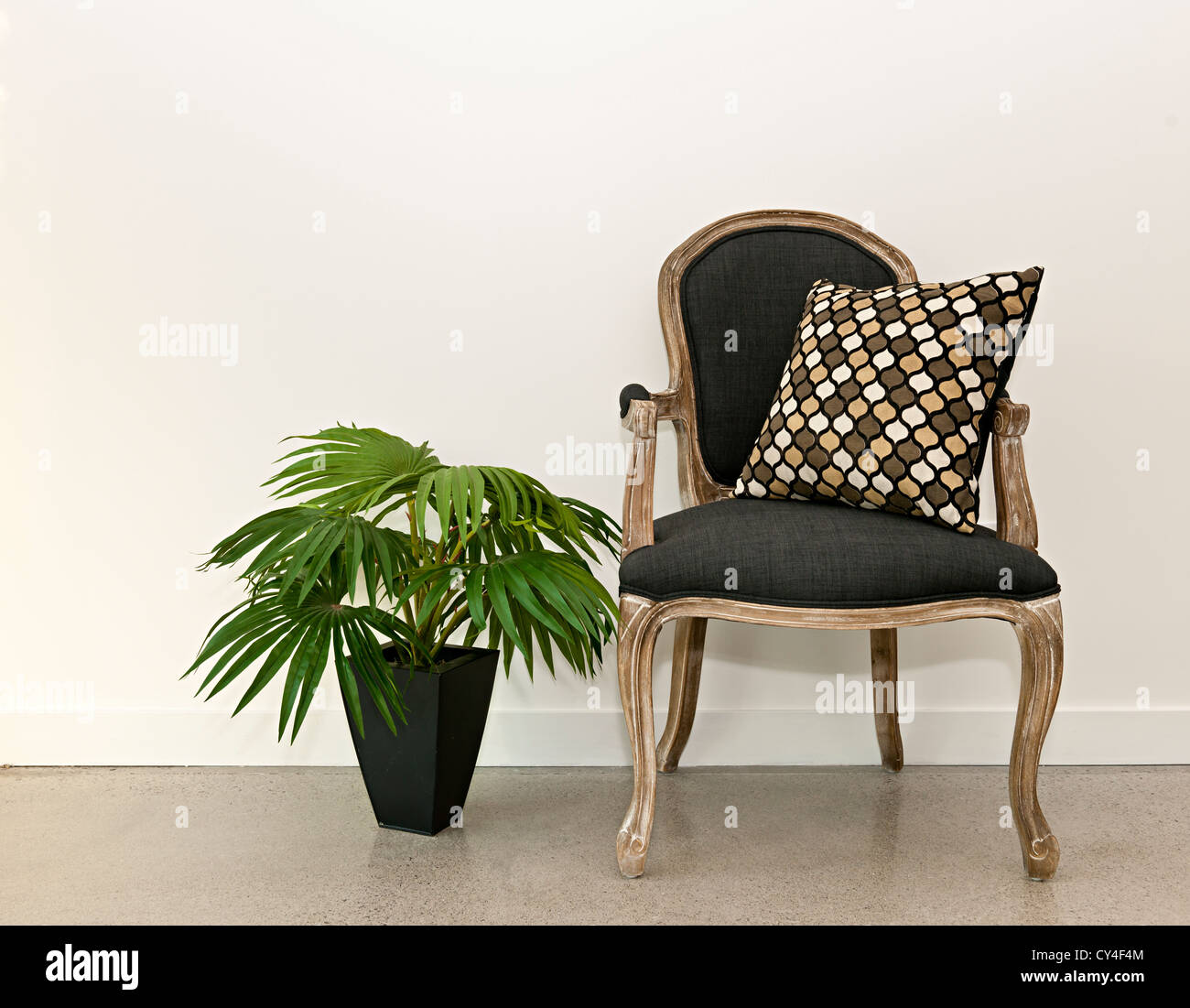 Antike Sessel Möbel mit Zimmerpflanze gegen weiße Wand, Einrichtungskonzept Stockfoto