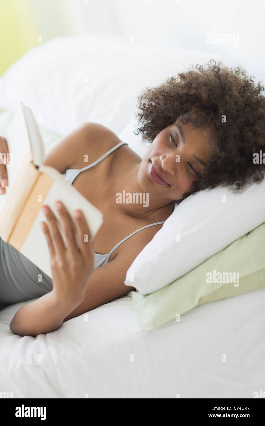 USA, New Jersey, Jersey City, Frau liest im Bett Stockfoto