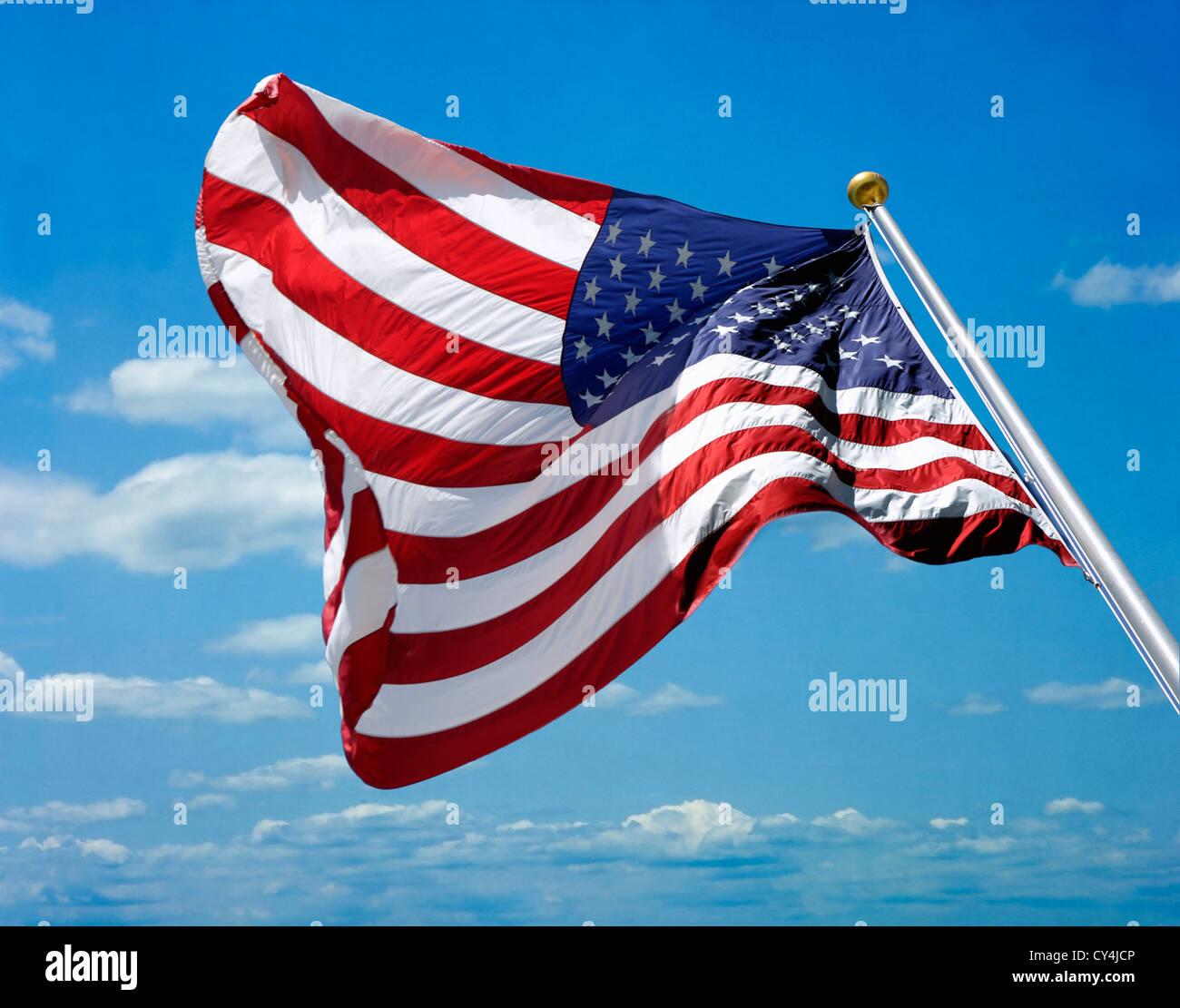 US-Flagge gegen blauen Himmel mit leichten Wolken geschossen aus einem niedrigen Winkel Stockfoto
