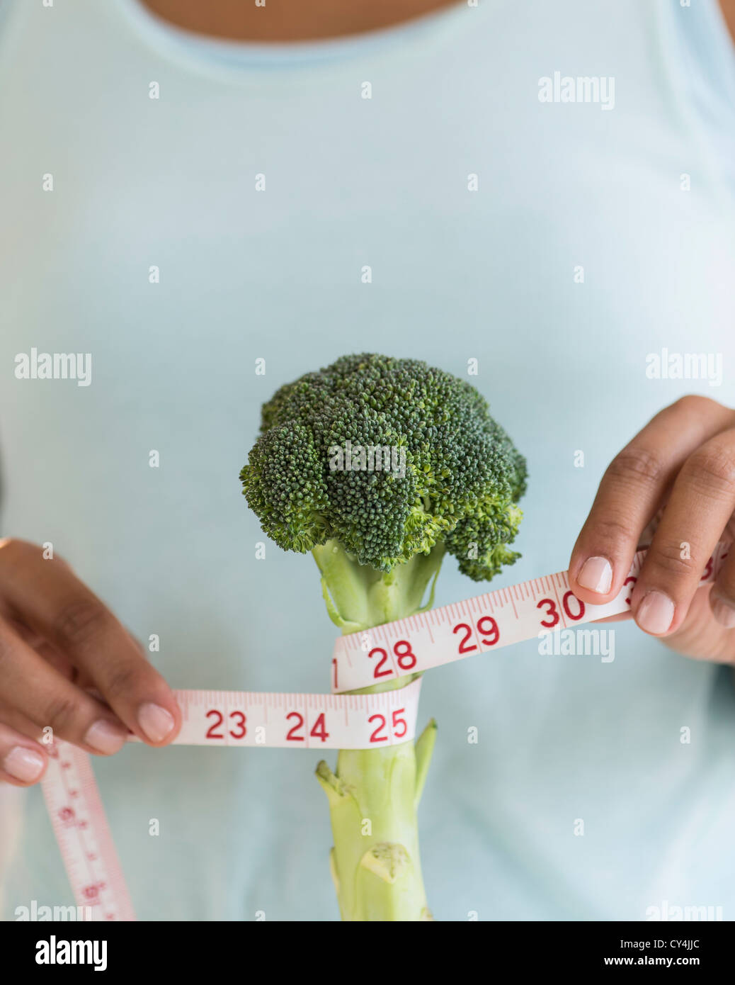 Frau, die Messung von Brokkoli Stockfoto