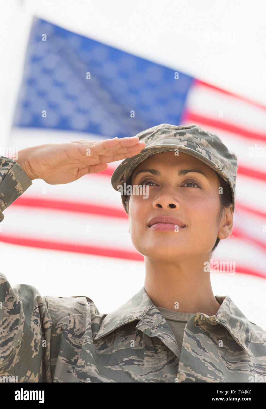 USA, New Jersey, Jersey City, weibliche Armee Soldaten salutieren, amerikanische Flagge im Hintergrund Stockfoto