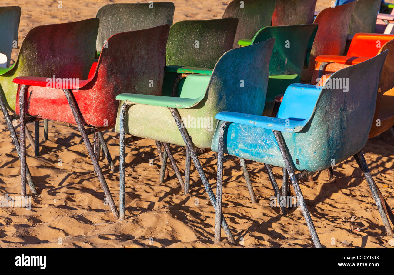 Alten verwitterten bunte Plastikstühle am Strand Stockfoto