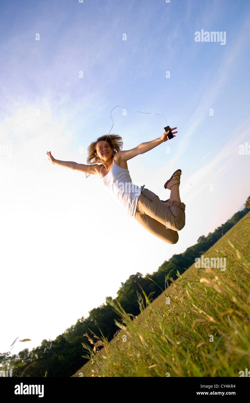 Teenager-Mädchen anhören von tragbaren Musik-Player in die Luft springen Stockfoto