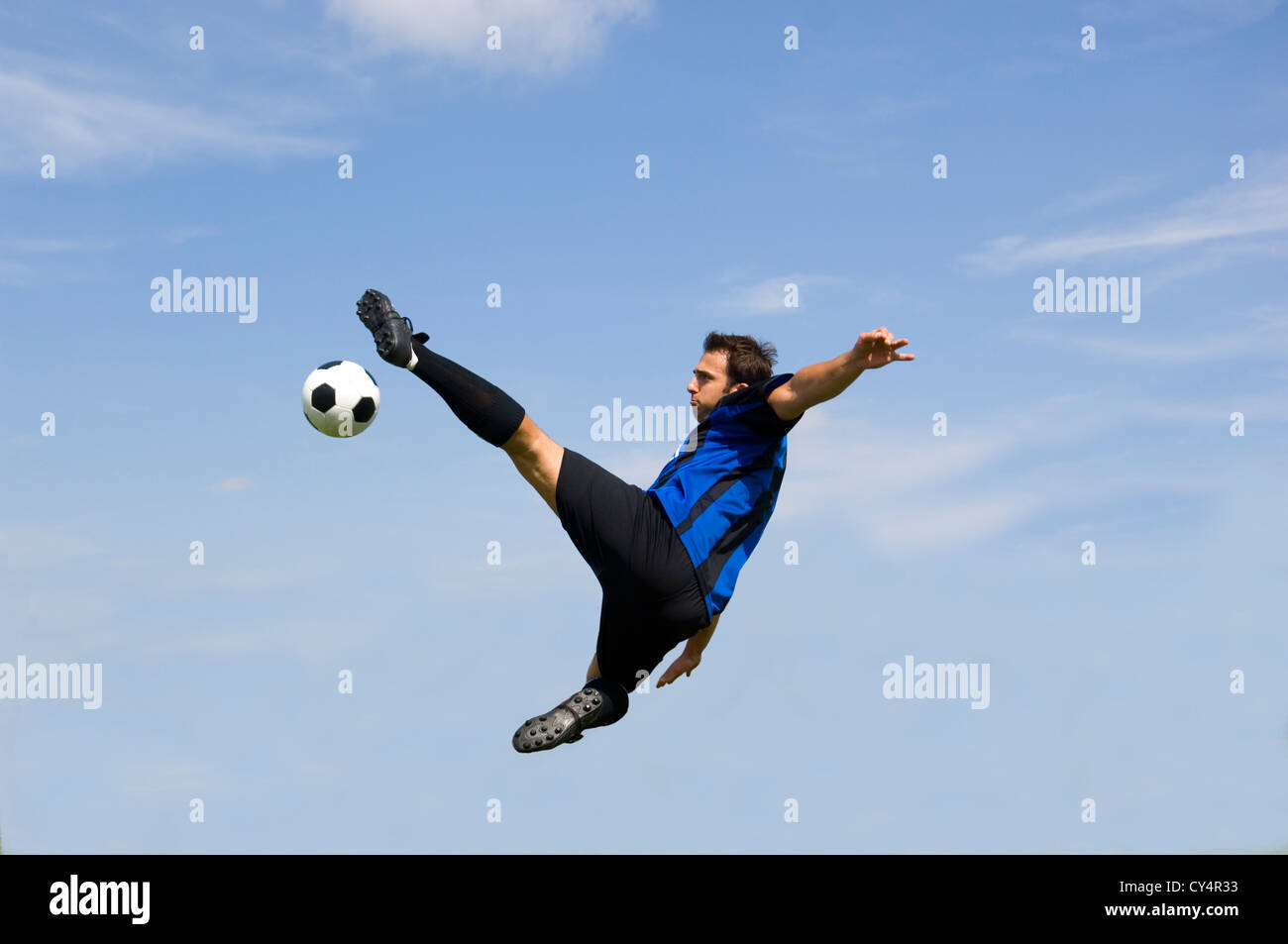 Fußball - Fußball-Spieler gegen blauen Himmel machen volley Stockfoto