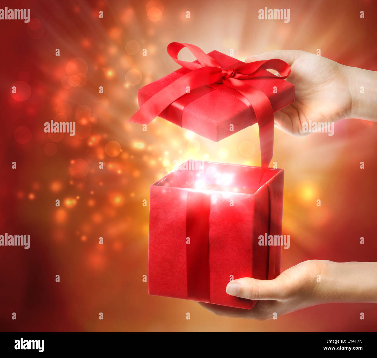 Frau mit einer roten Geschenkbox auf einem hellen Urlaub Lichter Hintergrund Stockfoto
