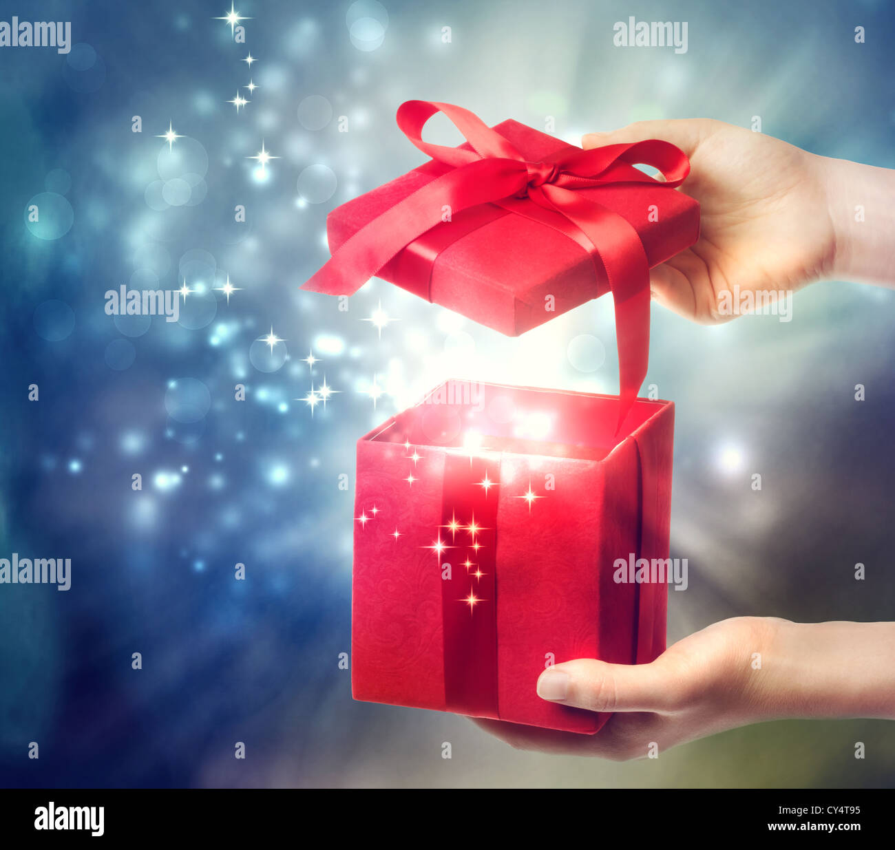 Frau mit einer roten Geschenkbox auf einem blauen Urlaub Lichter Hintergrund Stockfoto