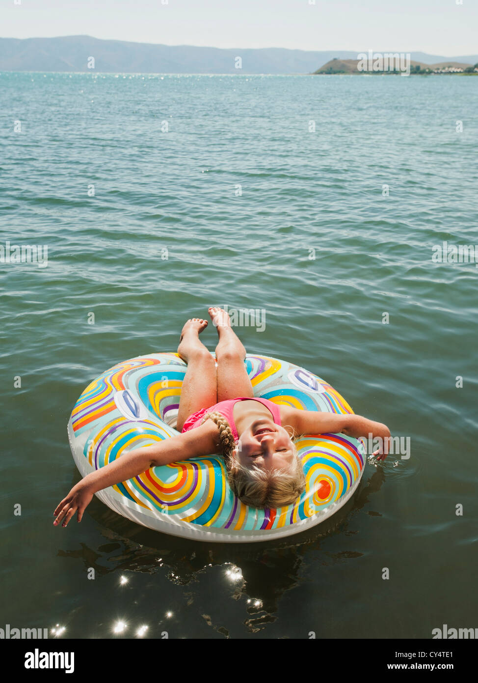 USA, Utah, Gartenstadt, Mädchen (4-5) schwimmt auf Wasser auf aufblasbaren Ring und lachen Stockfoto