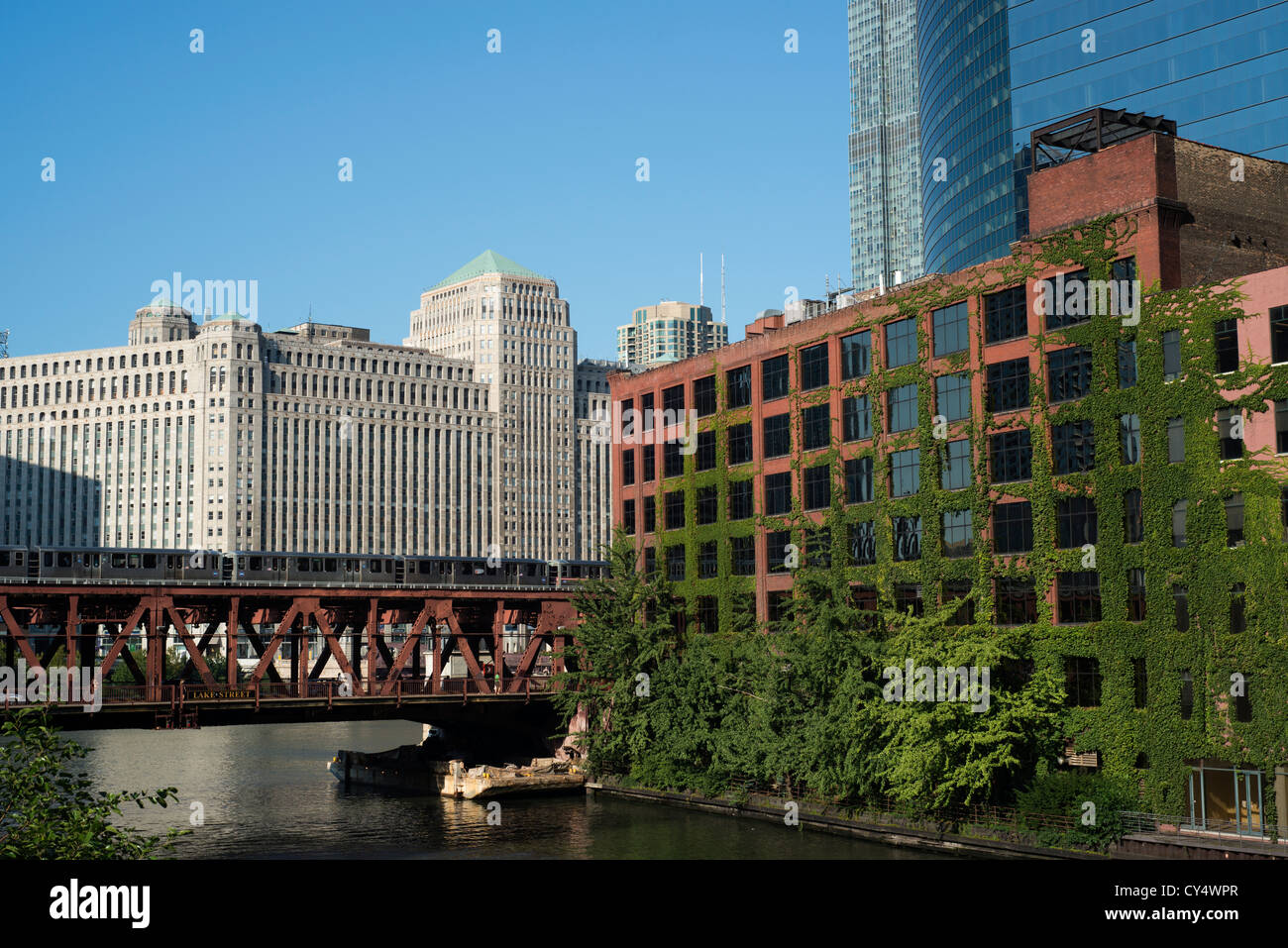 Efeu bedeckt, aufbauend auf der Chicago River mit Eisenbahnbrücke und Zug und Merchandise Mart im Hintergrund. Stockfoto