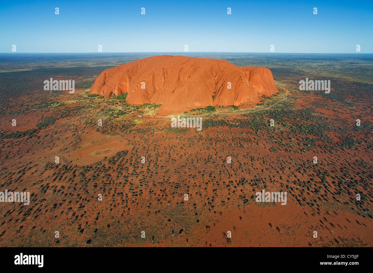 Majestätische Uluru entsteigen die rote Ebene. Stockfoto