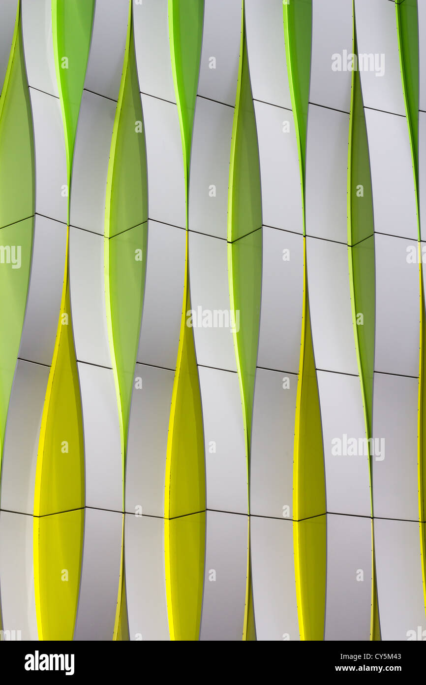 Detail einer modernen Fassade mit geschwungenen Elementen in Farbe: Silber, grün und gelb Stockfoto