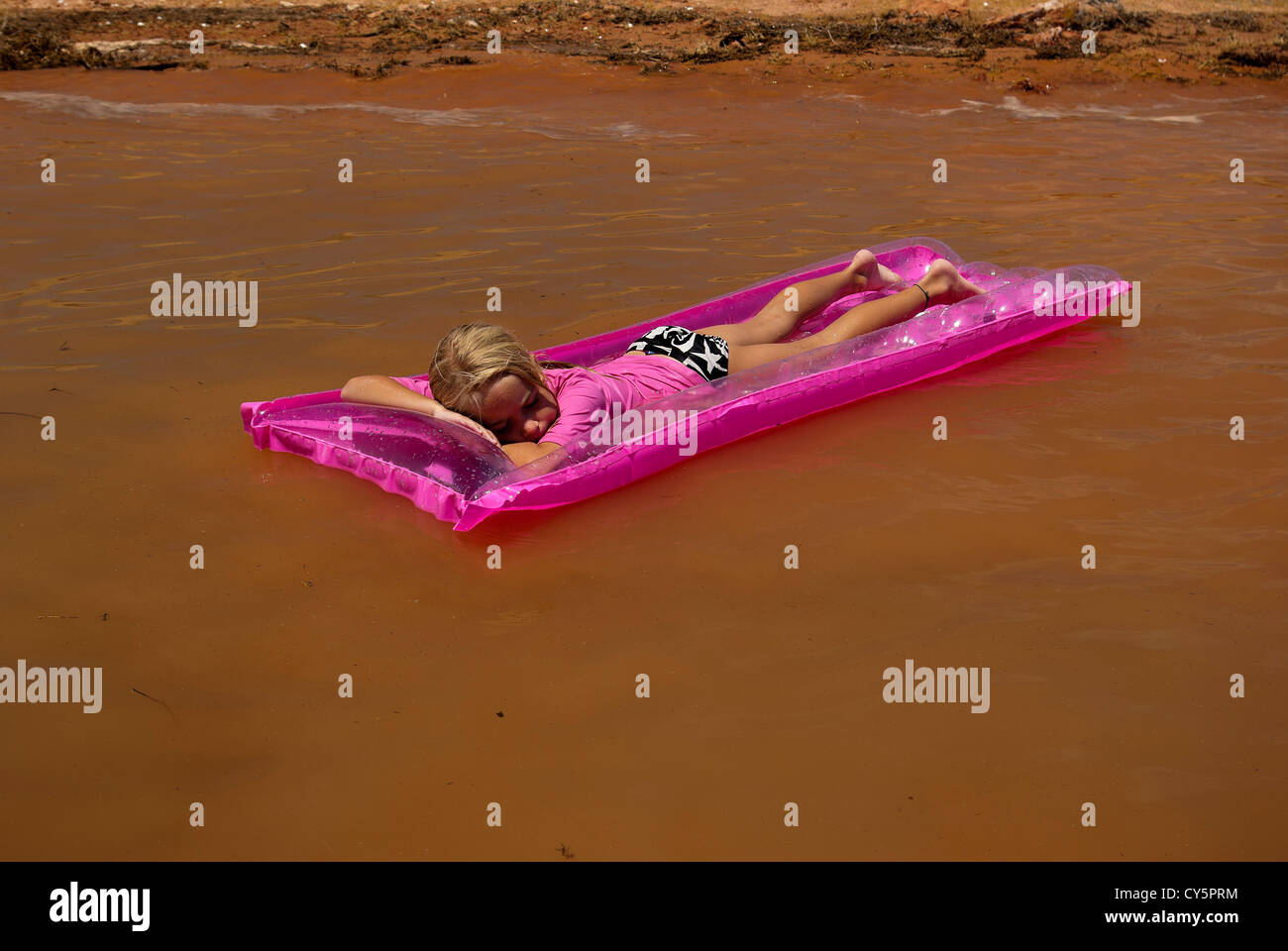 Kleines Mädchen schwebt auf rosa Floß am Lake Powell Stockfoto