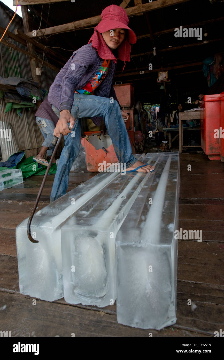 Eine Eis-Kaufmann verwendet Greifer Haken, um Baulärm Eisblöcke in Sisophon, Kambodscha Stockfoto