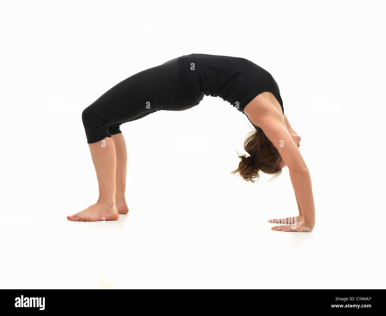 Kaukasische Frau auf dem Boden, im umgekehrten Yoga-Pose, Seitenansicht, gekleidet in schwarz auf weißem Hintergrund Stockfoto