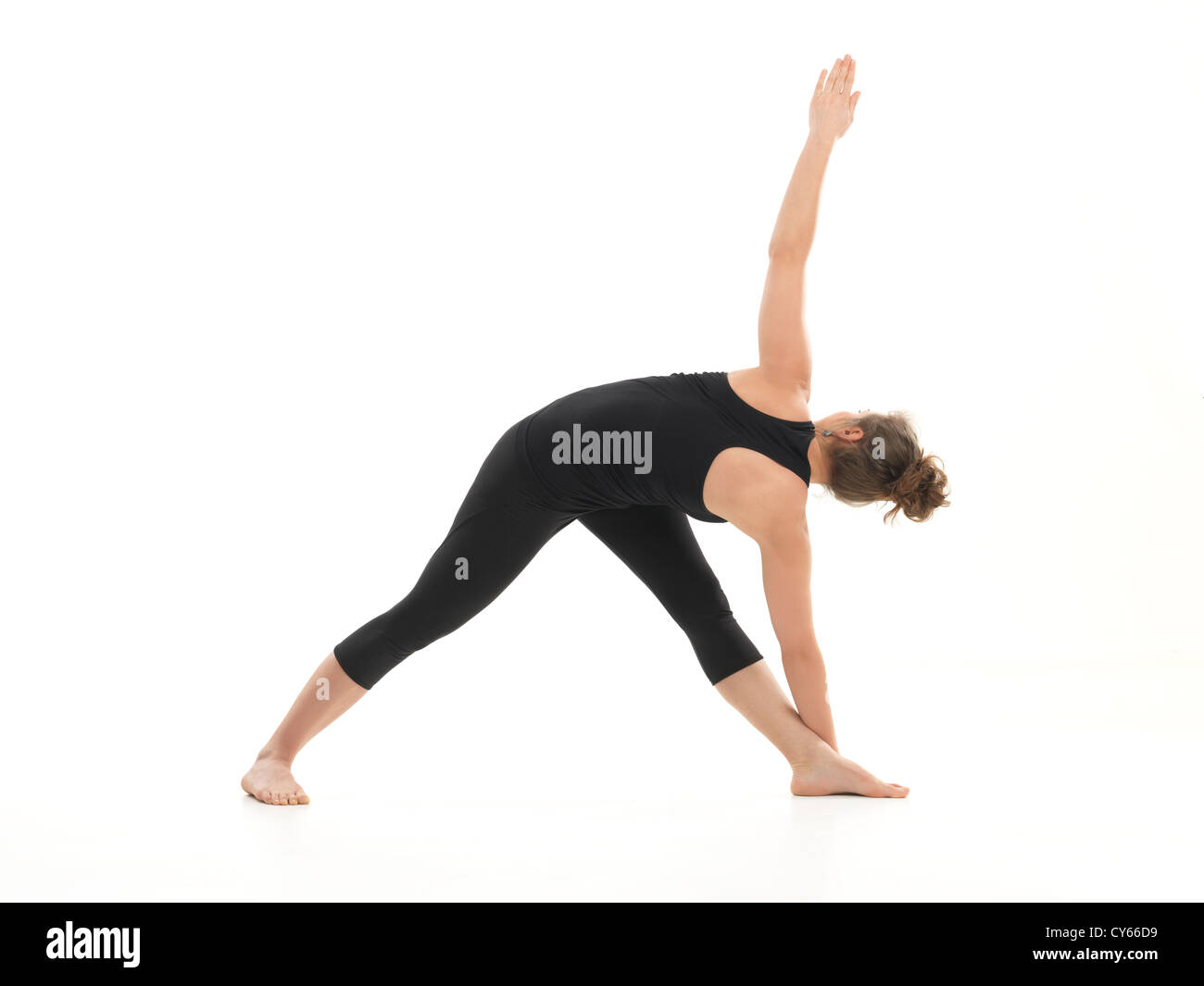 junge Frau in Streckung Yogastellung, gekleidet in schwarz auf weißem Hintergrund Stockfoto