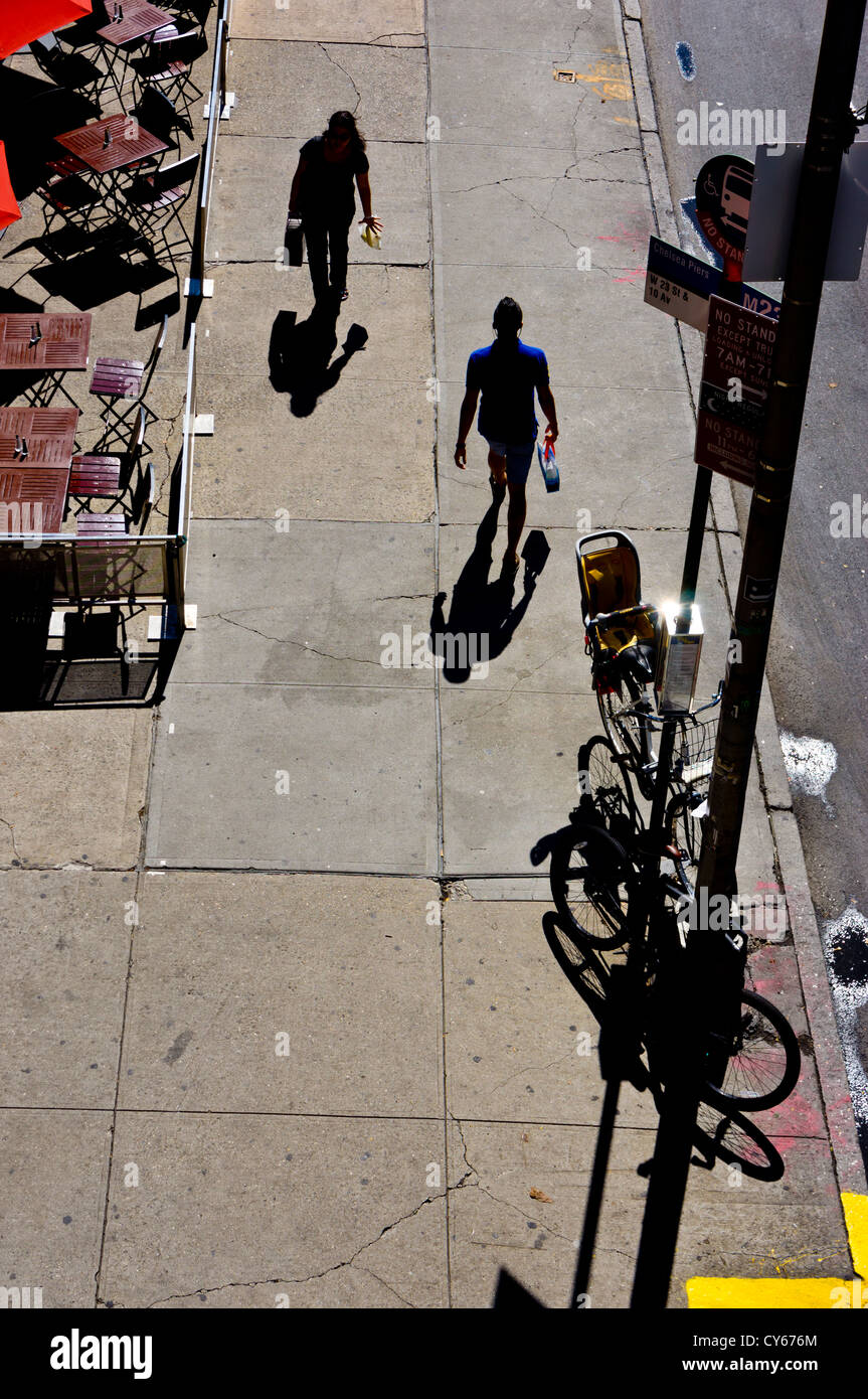 Zwei New Yorker Silhouette von der Sonne-Pass einander in einer ruhigen Straße. Stockfoto