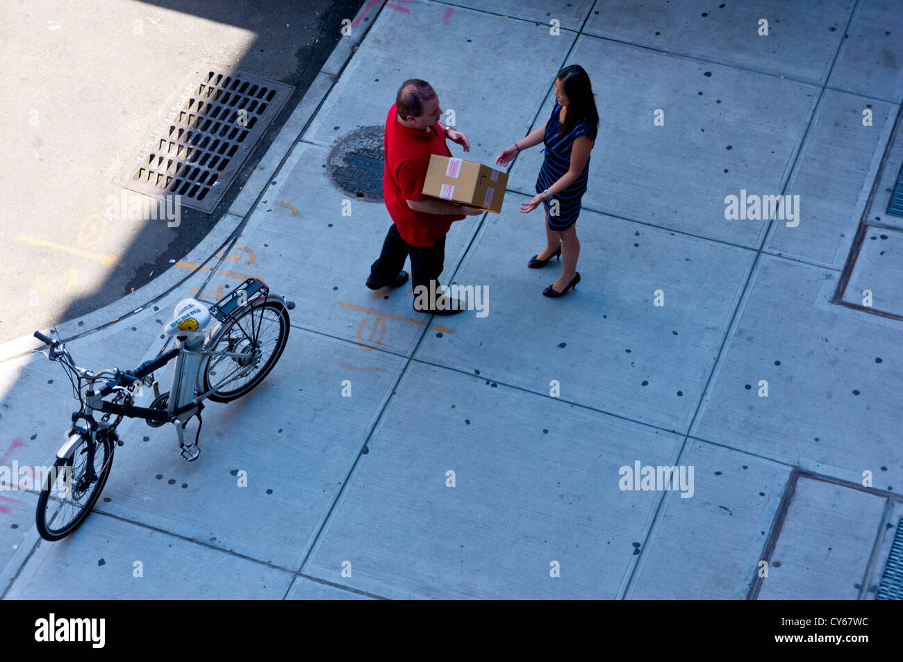 Ein Kurier liefert eine Paket - eine alltägliche New Yorker Straßenszene aus der High Line Stadtpark, Manhattan, New York betrachtet. Stockfoto