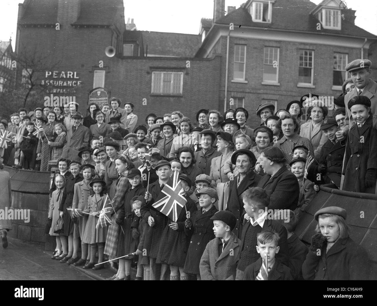 Massen säumen die Straßen für den Besuch der Königin in Shrewsbury am Freitag, dem 24. Oktober 1952. Großbritannien fünfziger Jahre Menschen Schulkinder Familien königlichen Besuch patriotische Flagge winkende Royalisten Stockfoto