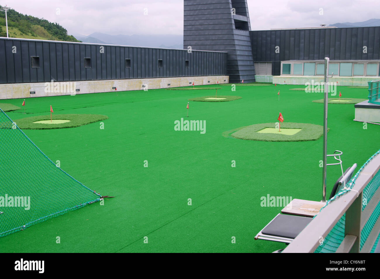 grünen Golfplatz mit Fahnen auf dem Dach des Wolkenkratzers Stockfoto
