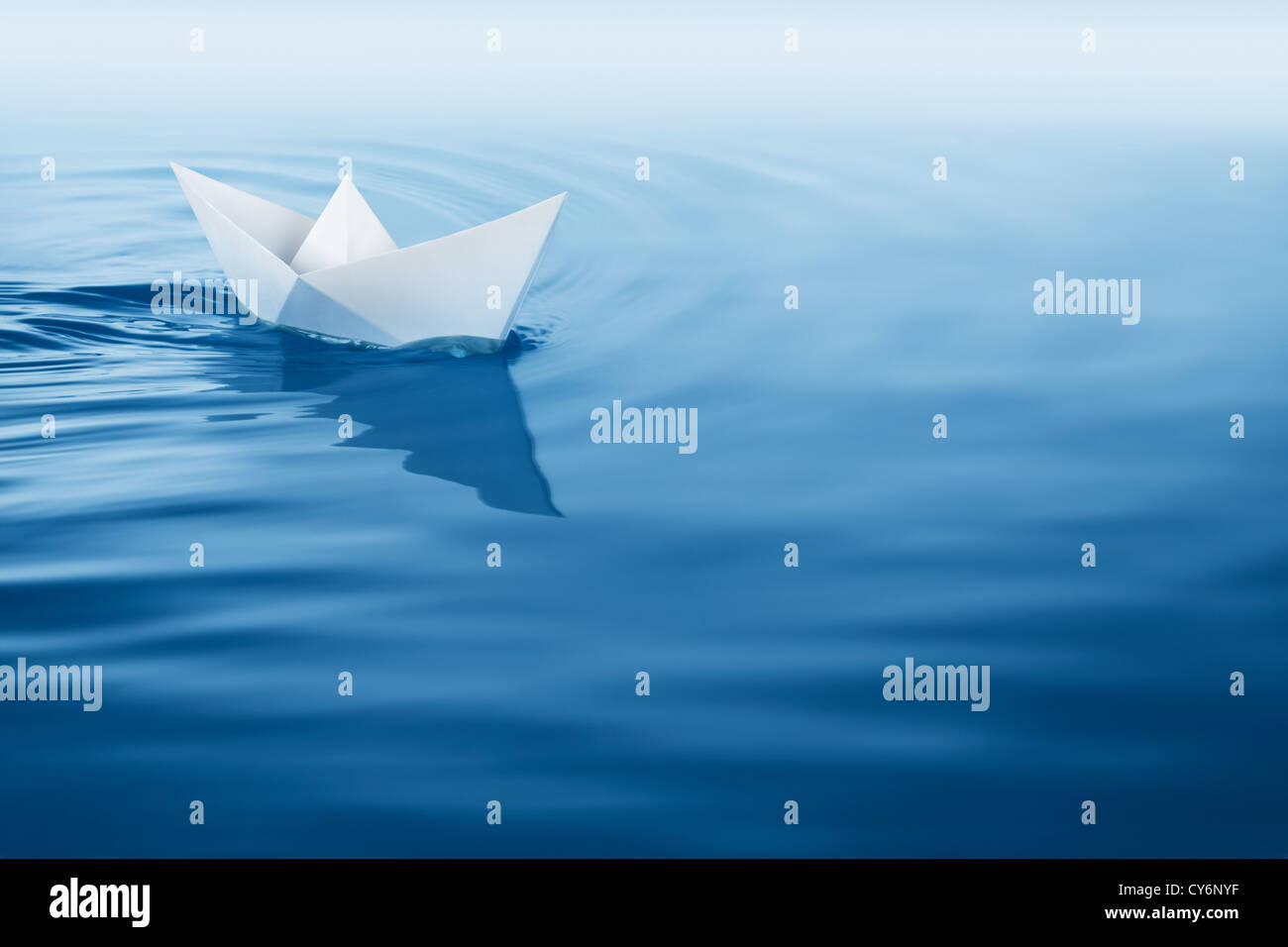 Papierboot Segeln auf blauem Wasser-Oberfläche Stockfoto