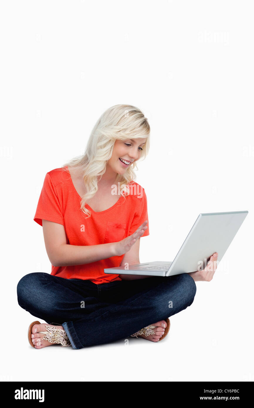 Blondine mit ihrer rechten Hand vor ihren Laptop-Bildschirm Stockfoto