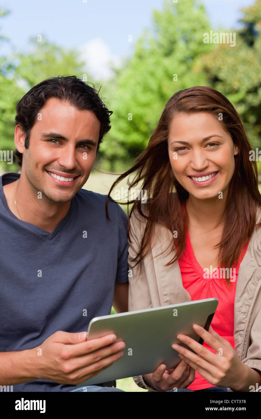 Mann und Frau nach vorne schauen einen Tablet mit gedrückter Stockfoto