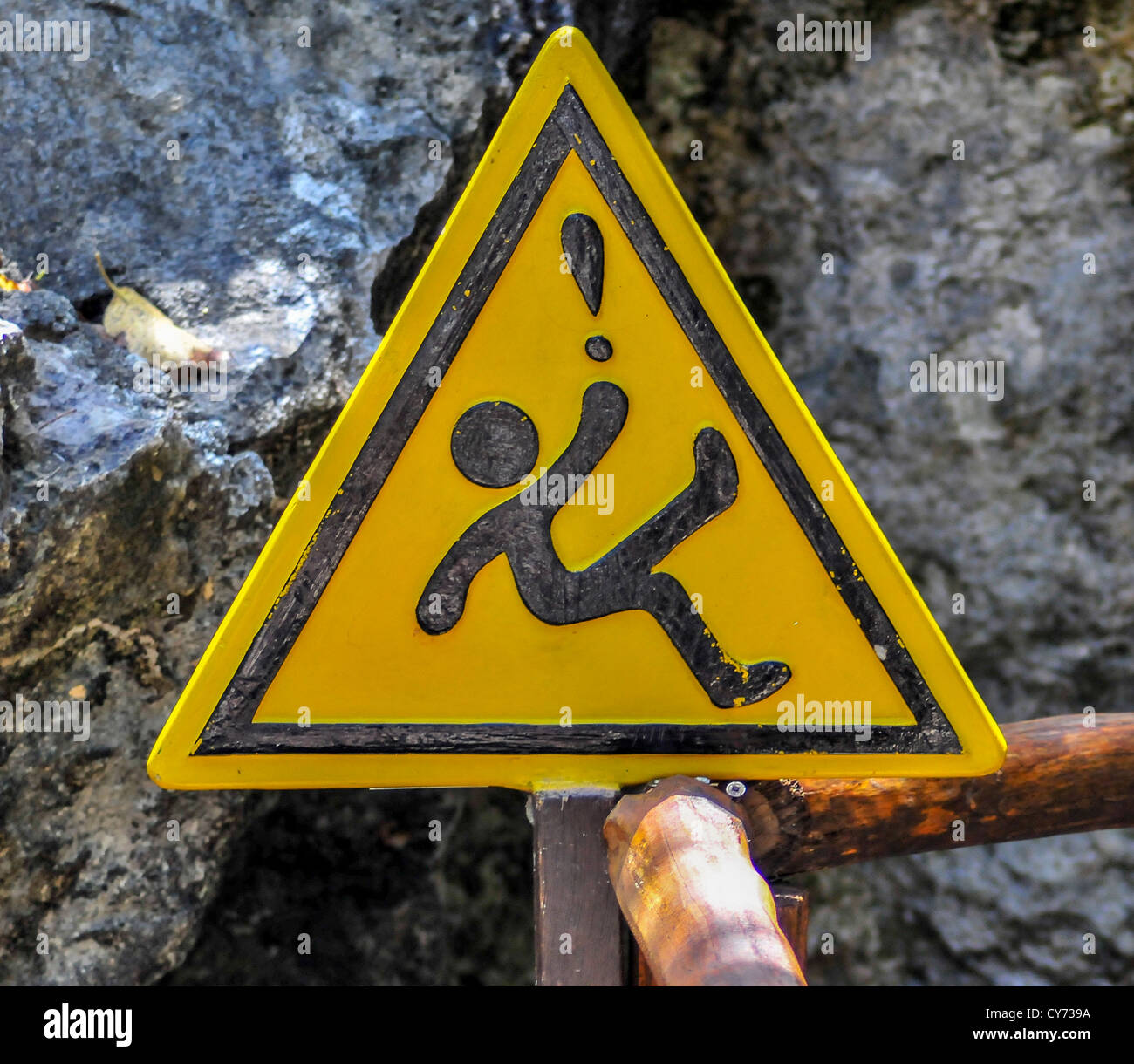 Eine gelbe dreieckige rutschige wenn nass Warnschild in México mexikanischen mit ein Ideogramm eine fallende Figur Dreieck Ausrufezeichen Stockfoto
