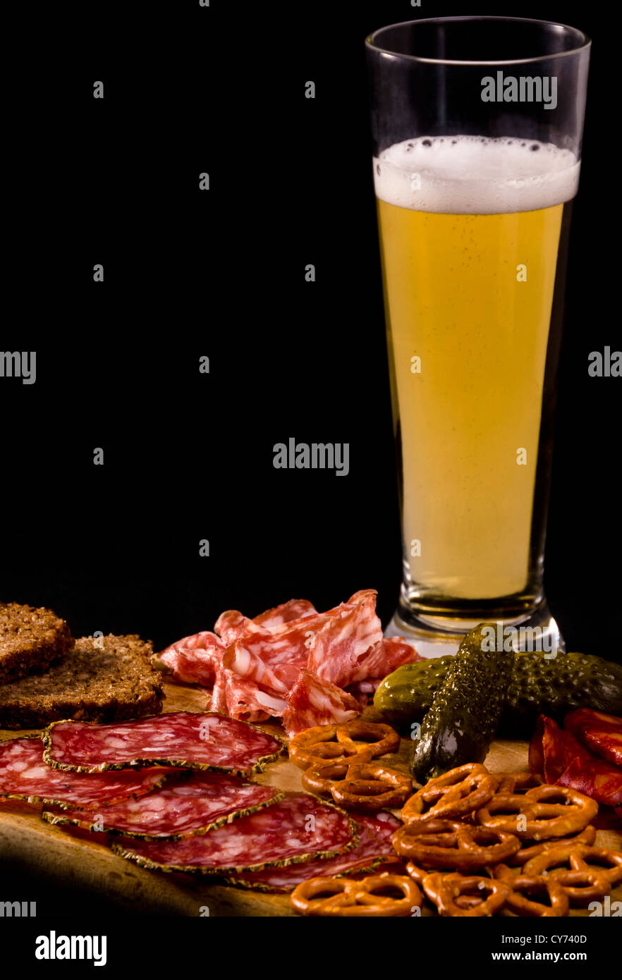 Eine Bar snack Salami und Gurken, serviert mit Schwarzbrot, ein erfrischendes Glas kühles Bier zu begleiten. Stockfoto