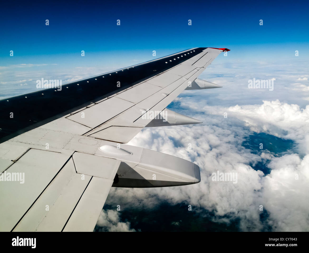 Blick auf die Flügel der Boeing 737 Verkehrsflugzeug fliegen über den Wolken mit dem Querruder Stockfoto