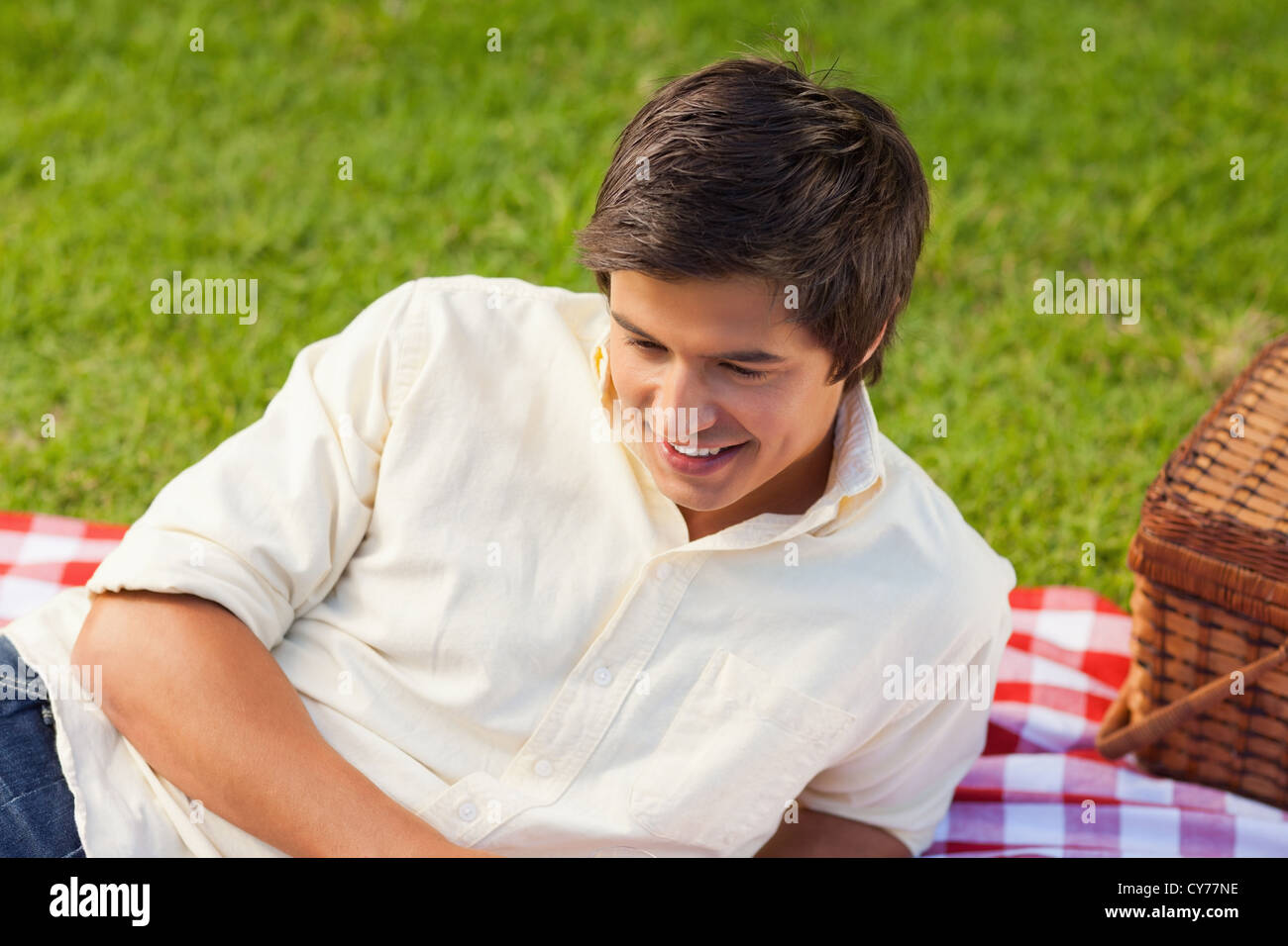 Mann lächelnd als He liegen auf einer Picknickdecke Stockfoto