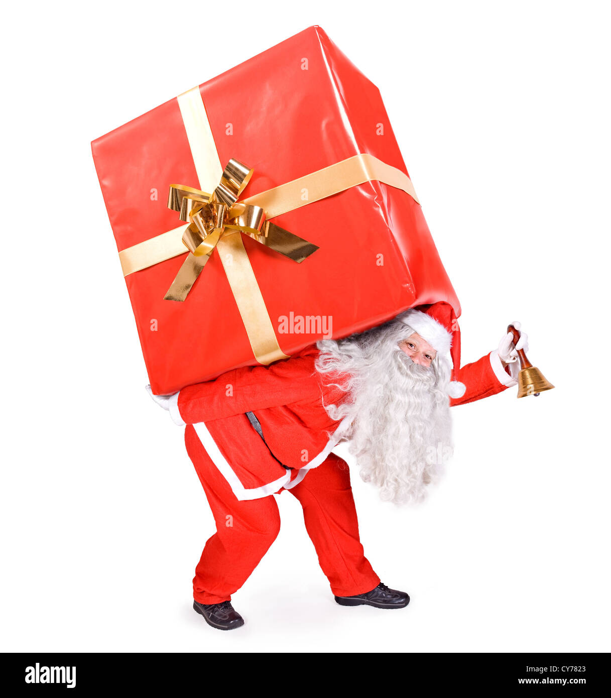 Santa Claus trägt ein großes Geschenk Stockfoto