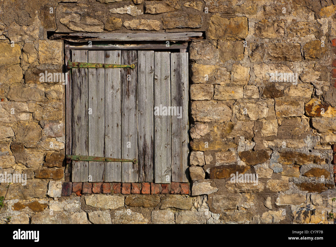 Architektonischen Hintergrund und Textur einer verwitterten Holz Tür gesetzt in einer alten Scheune Wand Stockfoto