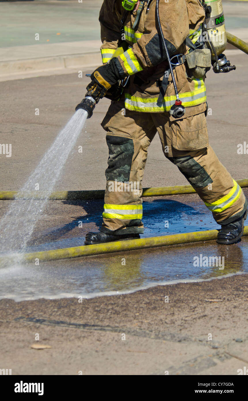 Fire Fighter Sprays off seinen Schlauch, bevor er es Weg setzt. Arizona. Stockfoto