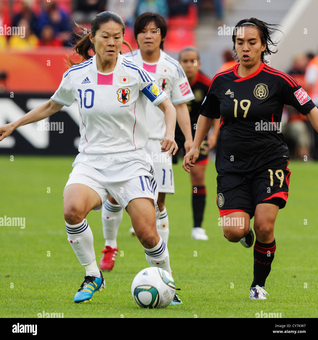 Japan-Team-Kapitän Homare Sawa (L) steuert den Ball gegen Monica Ocampo von Mexiko (R) bei einer FIFA Frauen WM-Spiel. Stockfoto