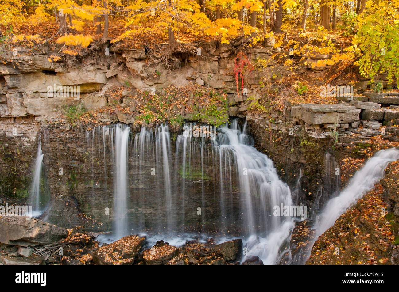Verträumter Wasserfall und volle Herbstfarben dominieren diese malerische Landschaft Stockfoto