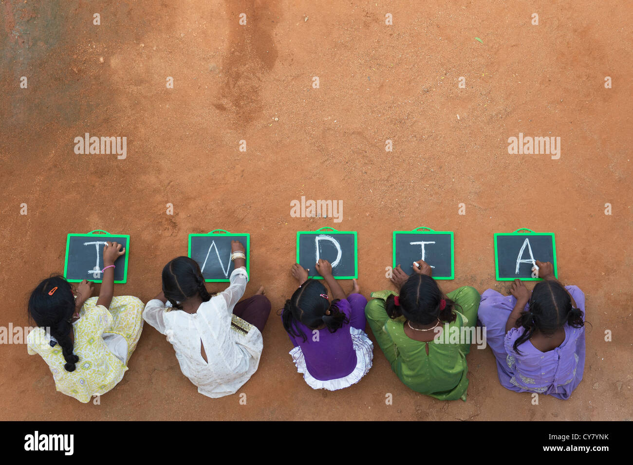 Fünf Mädchen, Indianerdorf mit Indien geschrieben auf einer Tafel in einem indischen Dorf. Andhra Pradesh, Indien. Textfreiraum Stockfoto