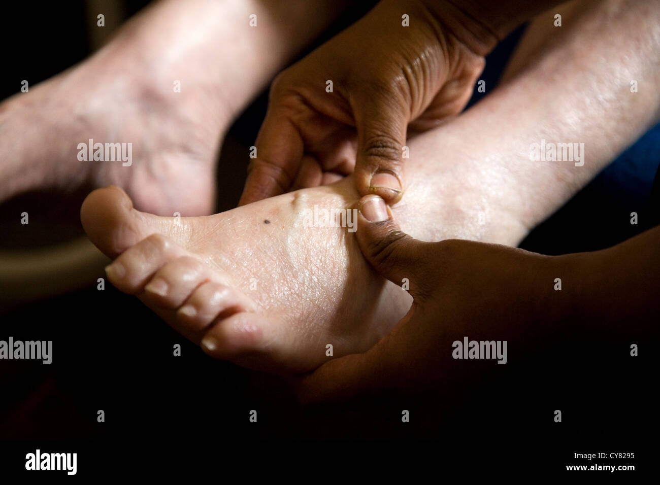 Den Fuß einer alten Frau massiert / Fußmassage auf Senior / Senioren / ältere Frau / Person. Stockfoto