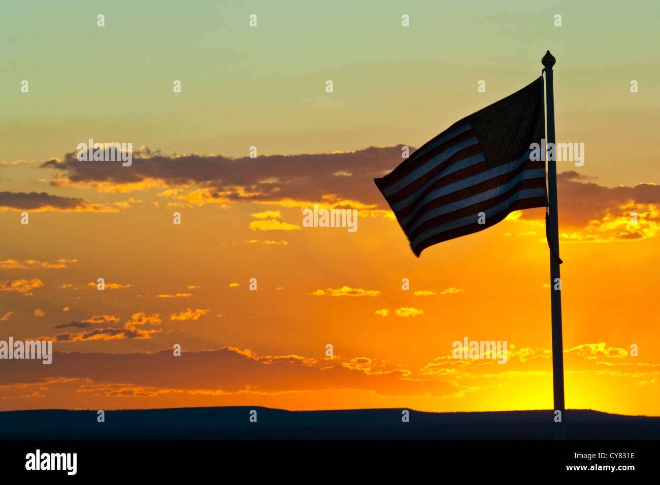 Sonnenuntergang hinter der amerikanischen Flagge winken in die Brise in der Nähe von Winslow, Arizona Stockfoto