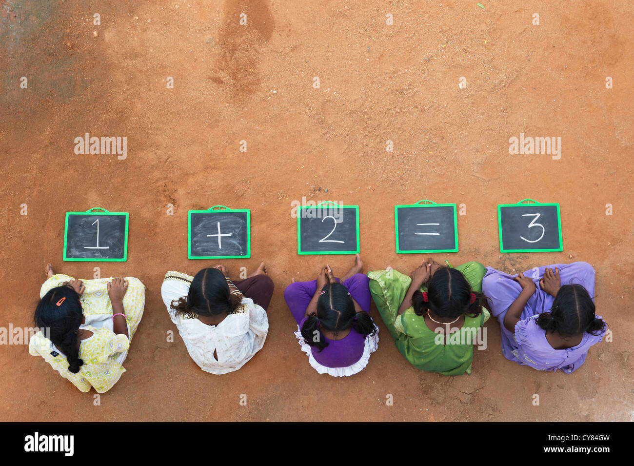 Fünf Mädchen, Indianerdorf mit 1 + 2 = 3 geschrieben auf einer Tafel in einem indischen Dorf. Andhra Pradesh, Indien. Kopieren Sie Raum. Stockfoto