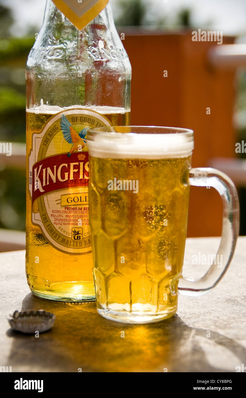 Vertikale Nahaufnahme von einer kühlen Flasche Kingfisher Bier und ein volles Glas auf einem Tisch in Indien. Stockfoto