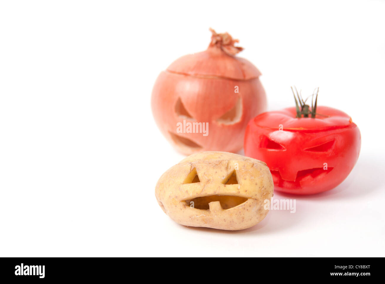 Halloween Gesichter geschnitzt in Gemüse wie Kartoffeln, Tomaten, Zwiebel  und statt Kürbis bilden spezielle Jack-o-Laternen Stockfotografie - Alamy