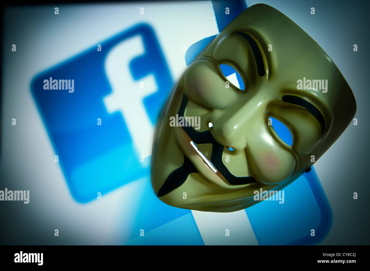 Facebook-Logo auf dem Bildschirm mit Guy Fawkes Vendetta V Anonymous Maske Stockfoto