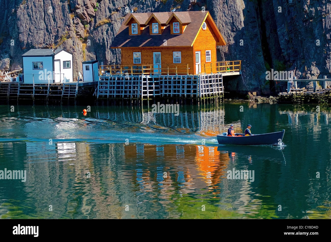 Ein paar Fischer navigieren ihr Handwerk durch ein Fischerdorf in Neufundland Stockfoto