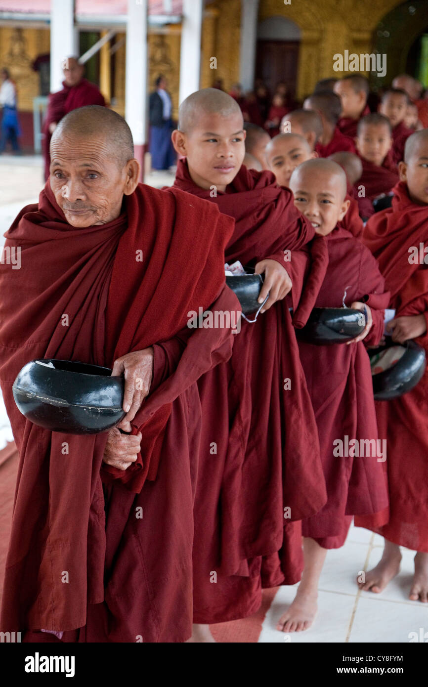 Myanmar, Burma. Buddhistische Mönche in der Schlange, Geschenke von einem wohlhabenden Spender erhalten. Alodaw Pauk Pagode, Inle-See, Shan-Staat. Stockfoto