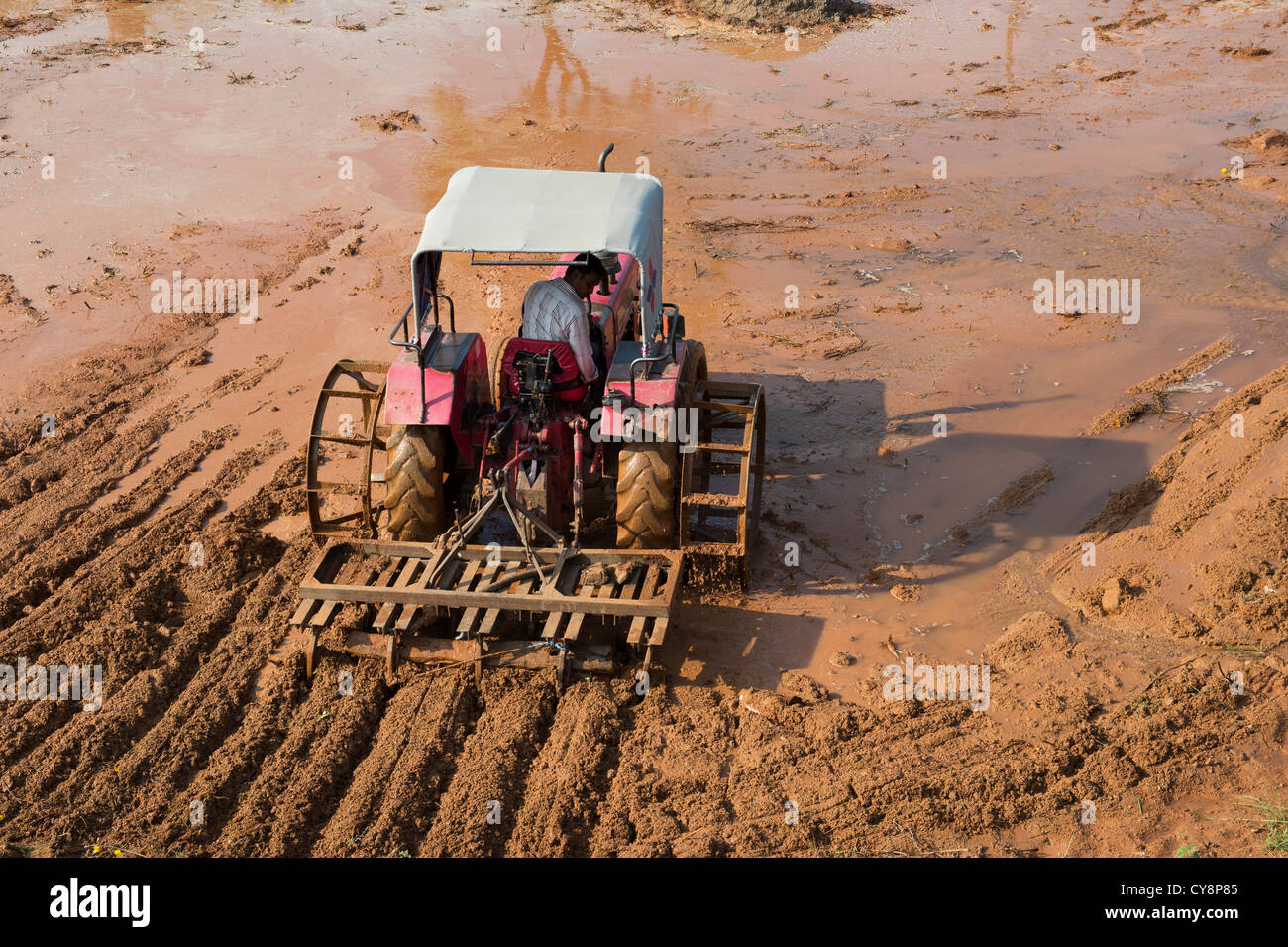 Pflügen Traktor vorbereiten ein Reisfeld Feld in der indischen Landschaft. Andhra Pradesh, Indien Stockfoto
