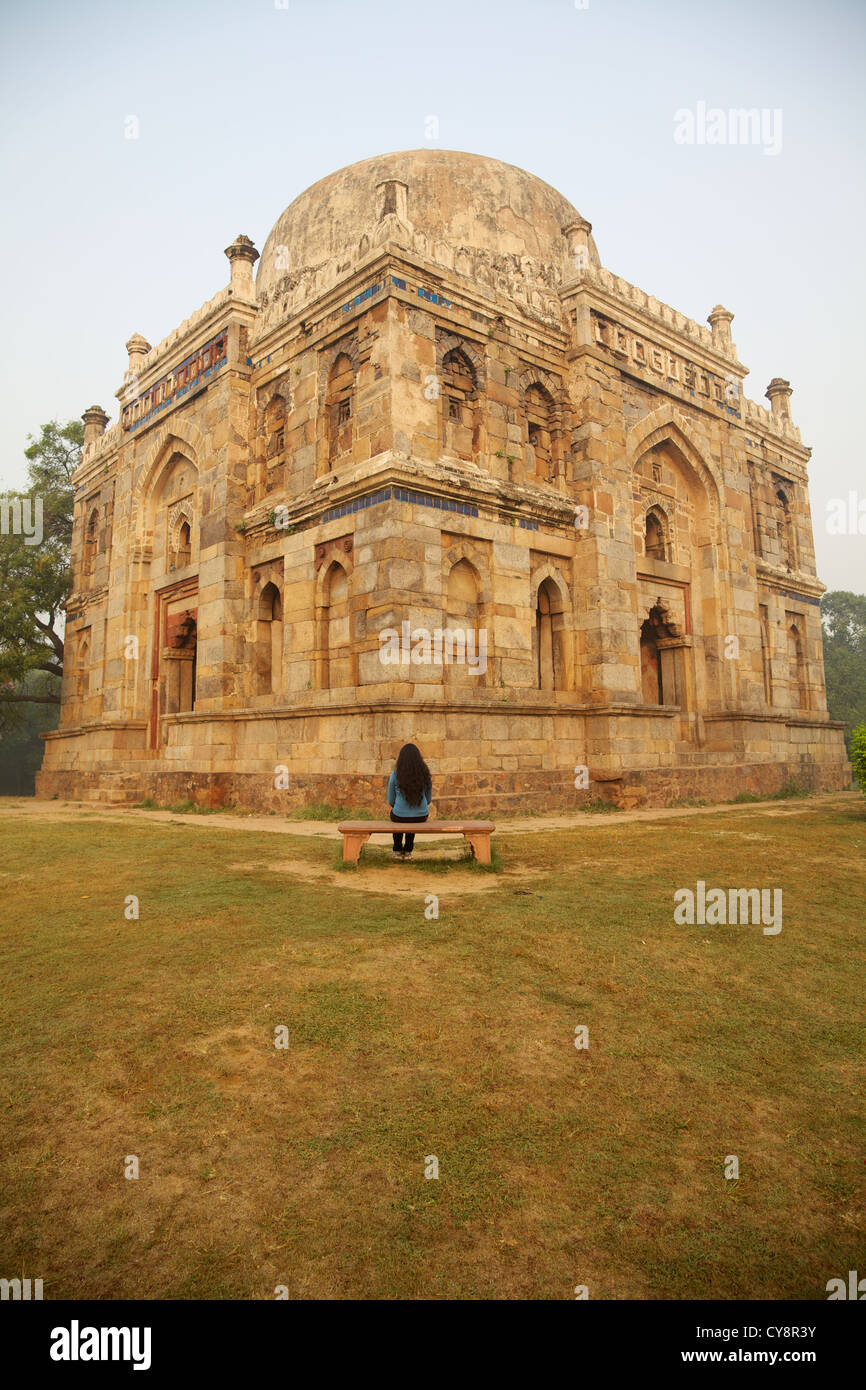 Eine Dame sitzt vor dem Shish Gumbad Lodhi Garten, Delhi Stockfoto